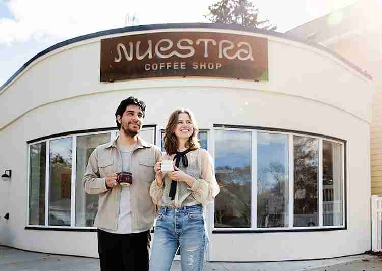 Antonio Velasquez and Nichola Hildebrand outside their coffee shop; at right, one of Nichola’s custom mugs