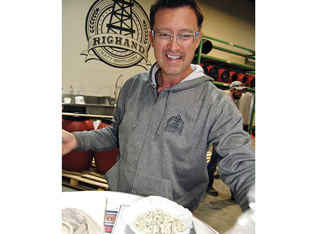 Rig Hand Distillery’s Geoff Stewart weighs fava bean flowers.