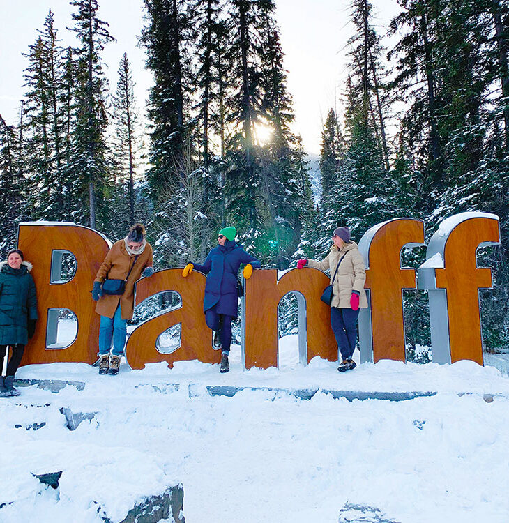 Weekend travelling companions at the Banff sign on Mount Norquay Road