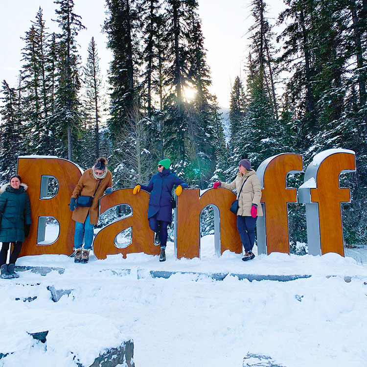 Weekend travelling companions at the Banff sign on Mount Norquay Road